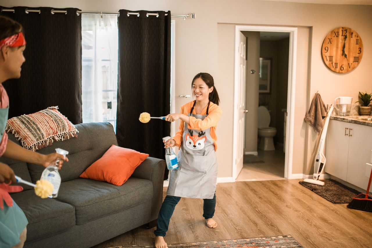 stats-img A cheerful couple engages in a playful cleaning session in their home.